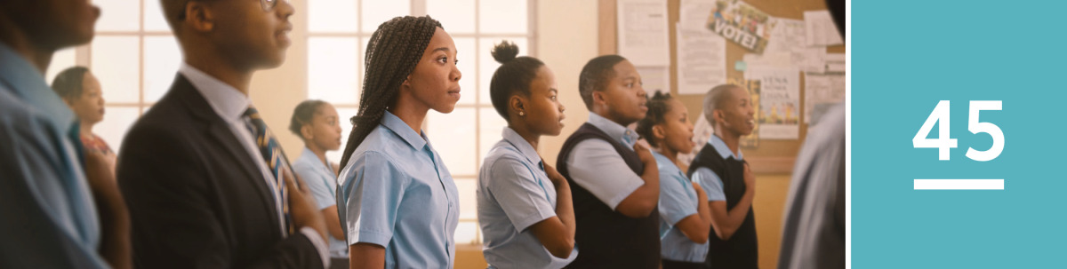 Image 1: A young sister respectfully stands during the pledge of allegiance but does not recite the pledge or place her hand on her heart like the rest of the students.