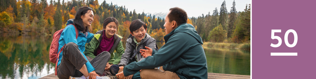 Image 1: A family talk together on a dock at a beautiful lake.