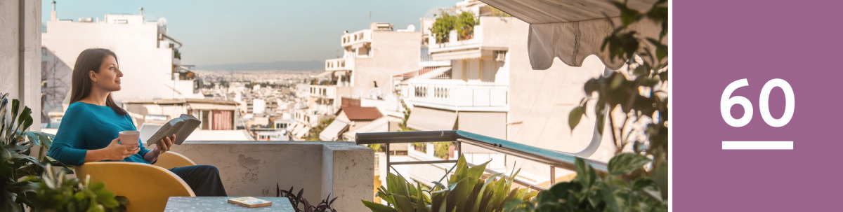 Image 1: A woman sits on her balcony and reads the Bible. The book ‘Draw Close to Jehovah’ is on a table beside her.