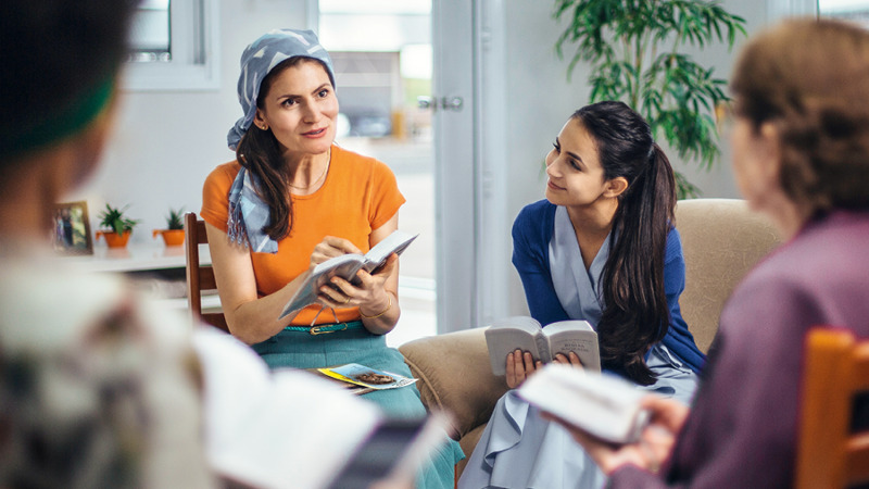 IMAGE 3 PICTURE DESCRIPTION: A sister conducting a meeting for field service. She is seated and wearing a head scarf.