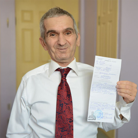 Teymur holding up his presidential pardon in 2018